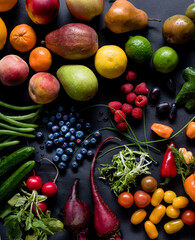 An Assortment of fruits and vegetabels on a black background