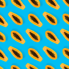 Fresh ripe papaya seamless pattern on blue background. Tropical abstract background. Top view. Creative design, minimal flat lay concept. Trend tropical fruit food background pattern