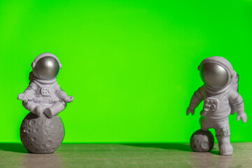 Two Plastic toy astronaut on green chroma key background Template Mock up Copy space. Concept of...