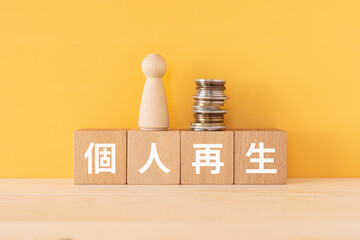 個人再生と書かれたブロックと人形とコイン