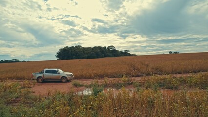 Obraz na płótnie Canvas Farmer driving pickup truck in soy farm
