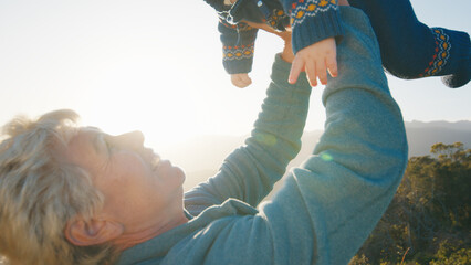 Elderly woman plays with infant baby outdoor