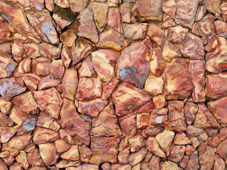 Texture composed of beautiful red colored stones, with uneven and varied formats and distribution