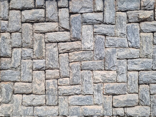 Texture formed by a panel of gray stones, uniformly placed between vertical and horizontal