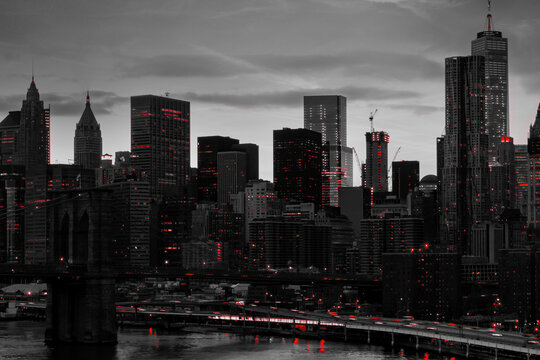 Red lights shining&nbsp;in black and white night time cityscape with the Brooklyn Bridge and buildings of Manhattan in New York City