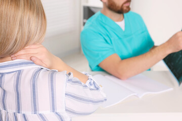 Obraz premium Doctor with neck MRI scan consulting patient in hospital, closeup