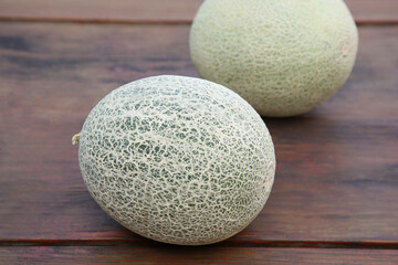 Whole ripe cantaloupe melons on wooden table