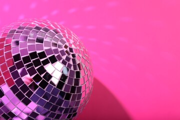 Shiny disco ball on pink background, closeup. Space for text