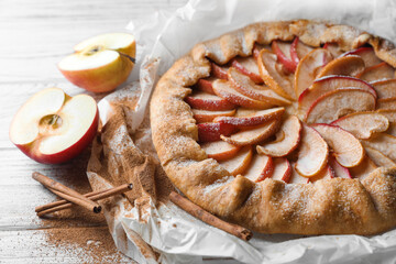 Delicious apple galette and cinnamon on wooden table