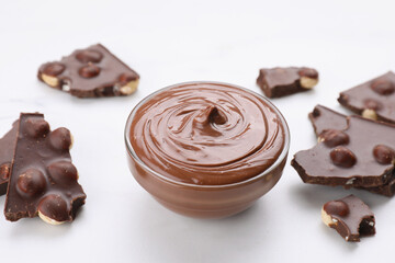 Pieces of tasty chocolate and sweet paste on white table, closeup