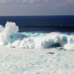 Fototapeta premium wave breaking by day with cloudy sky