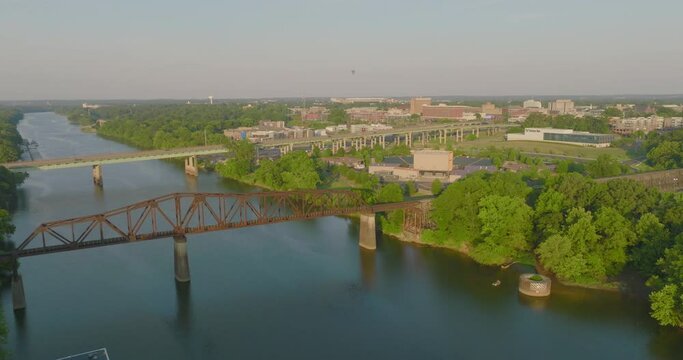Aerial Shot Of Black Warrior Railroad Bridge In City, Drone Flying Backwards Over River On Sunny Day - Tuscaloosa, Alabama