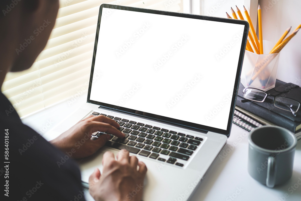Poster view over man shoulder hands typing on keyboard of laptop computer at desk. blank screen for your te