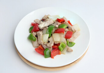 Stir fried pork with sweet peppers, onion and black pepper on white dish. Top view ,white background.