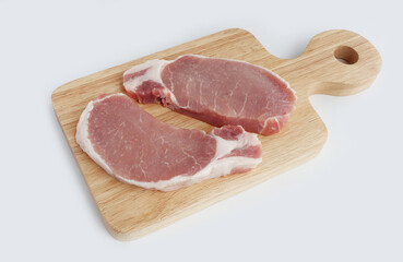 Organic raw pork meat on wooden chopping board on white background. Top view.