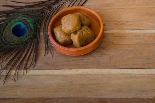 Mathura ka peda is served on a clay plate with peacock feather during celebration of Krishna janmashtami. This traditional Indian sweet originated in mathura is made of khoya or Mawa, ghee and sugar.
