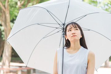 梅雨に傘を差すアジア人女性(憂鬱)
