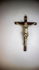 a cross hung on a white wall