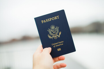 Close-up of a US passport with immigration, visa, citizenship, and travel paperwork on a wooden table