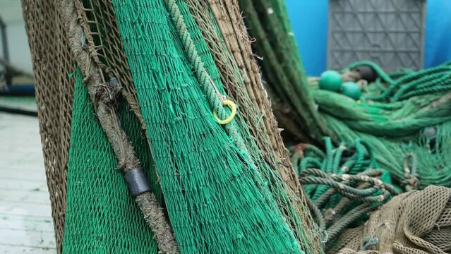 Large fishing drag nets piled up on Marine vessel boat ready for work