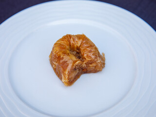 baklava rolls nest, oriental dessert made of phyllo, nuts, butter and syrup served in white plate. Traditional turkish, arabic, jewish sweet