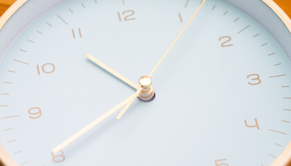 Close-up of a clock face where the hour hand is between 10 and 11, the minute hand is on 8.
