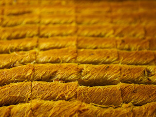 Pistachio kadayif on tray. Traditional Middle Eastern Flavors. The local name of kadayif Fistikli kadayif. Top view, close up, full frame background.