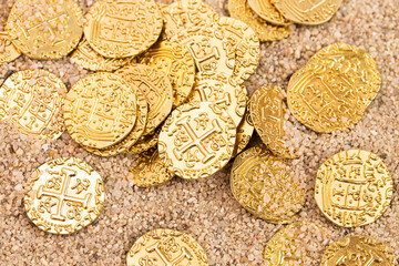 Buried Pirate Treasure Gold Coins in the Sand on a Sandy Beach