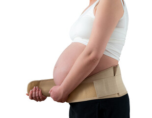 Pregnant woman putting on supporting bandage to reduce backache. Orthopedic abdominal support belt...