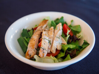 Italian salad with chicken meat. Fresh vegetable salad with chicken breast. Meat salad with chicken fillet and fresh vegetables in bowl, top view