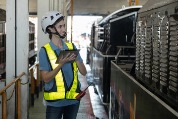 Portrait of Engineer train Inspect the train's diesel engine, railway track in depot of train
