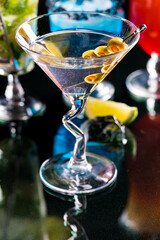 A classic martini with a cocktail pick of olives, ready for drinking.