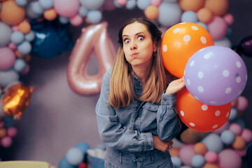 Funny Woman Holding Colorful balloons at a Party. Happy entertainer making expressive faces at kids party
