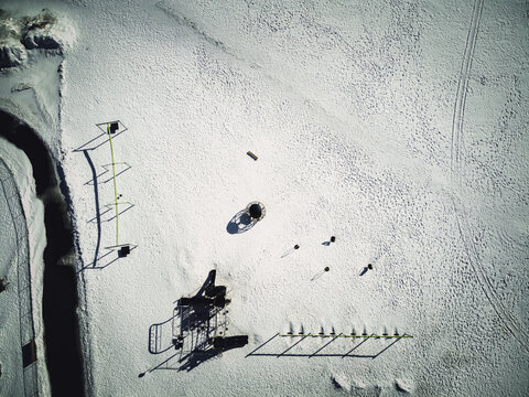 Aerial Overhead Drone View Of School Playground Equipment Covered In Snow.