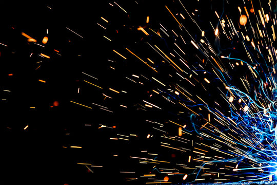 Close up view and background of the gas metal arc welding (GMAW) process with sparks, light, bokeh effect and smoke.