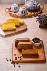 Homemade chocolate sponge cake or chiffon cake on white plate so soft and delicious with ingredients: eggs, flour, milk on wood table. Homemade bakery concept for background and wallpaper.