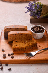 Homemade chocolate sponge cake or chiffon cake on white plate so soft and delicious with ingredients: eggs, flour, milk on wood table. Homemade bakery concept for background and wallpaper.