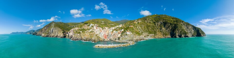 Fototapeta na wymiar Aerial panorama top view of Riomaggiore colorful fishing village one of the five Cinque Terre Villages in national park, sequence of hill cities along the coastline of Ligurian Sea in Italy. 