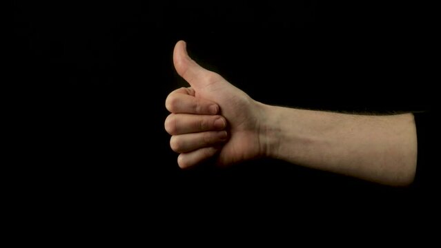 Static shot of a man holding his arm up and doing a thumbs up gesture