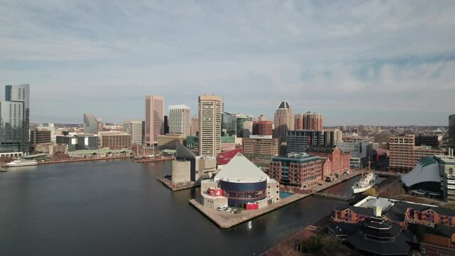 Low rising aerial of National Aquarium in Baltimore, MD, downtown skyline
