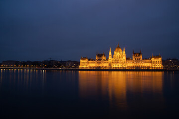 Budapest parliament illuminated at night and Danube river, Hungary - Powered by Adobe