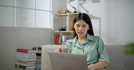 Portrait of Asian young woman using laptop at home