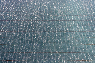 Rear view of a dirty car window covered with dust closeup view