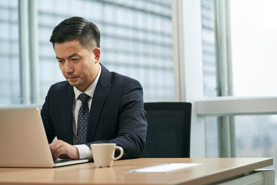 asian business man working in office using laptop computer