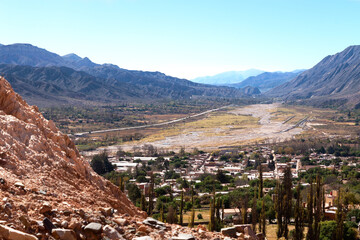 Tilcara town panoramic view seen from a height over the valley between Andes mountain ranges . 
