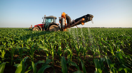 Tractor spraying pesticides at corn fields