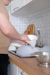 Close-up of a man washing dishes in the kitchen sink