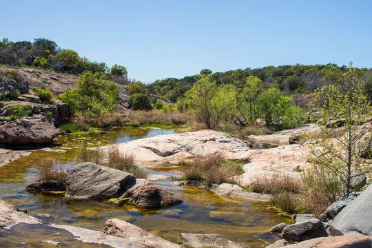 A stream known as Spring Creek flows over the sandstone formations on a beautiful spring day in the Texas Hill Country