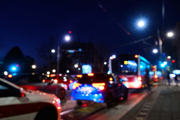 Fototapeta na wymiar Defocused lights of cars jamming on city street. Evening traffic jam. Blurred tail lights of cars, buses, traffic lights and lanterns