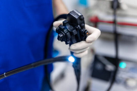 Doctor proctologist holding endoscope during colonoscopy. Probe colonoscope. Doctor gastroenterologist with probe to perform gastroscopy and colonoscopy